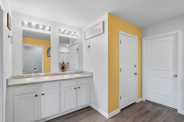 bathroom featuring wood-type flooring, a textured ceiling, and vanity