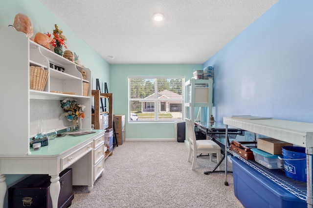 carpeted office space featuring a textured ceiling