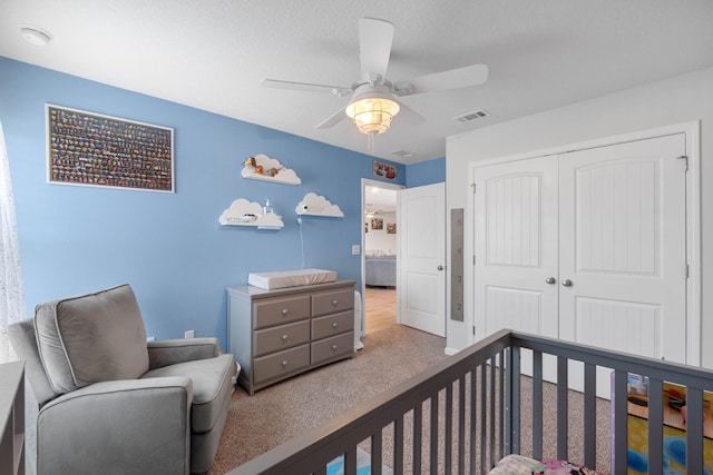 carpeted bedroom featuring ceiling fan and a closet