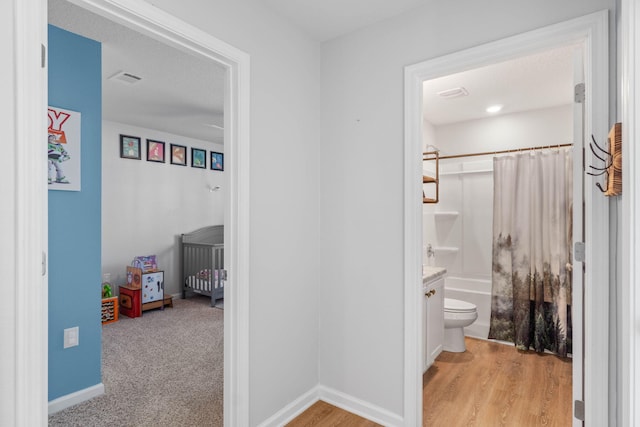 full bathroom featuring toilet, shower / tub combo with curtain, wood-type flooring, and vanity