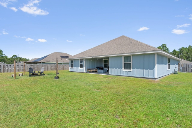 rear view of property featuring a lawn and a patio area