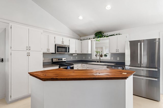 kitchen featuring white cabinets, a center island, stainless steel appliances, and butcher block counters