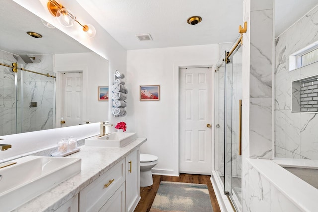 bathroom with vanity, hardwood / wood-style flooring, toilet, and walk in shower