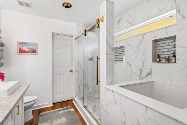 bathroom with toilet, vanity, wood-type flooring, and walk in shower