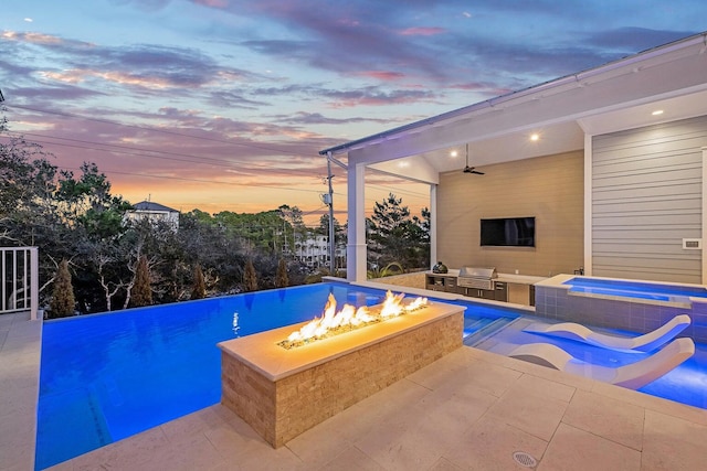 view of pool with a hot tub, ceiling fan, a patio area, and a fire pit