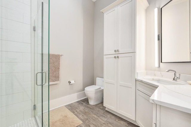 bathroom with walk in shower, wood-type flooring, vanity, and toilet