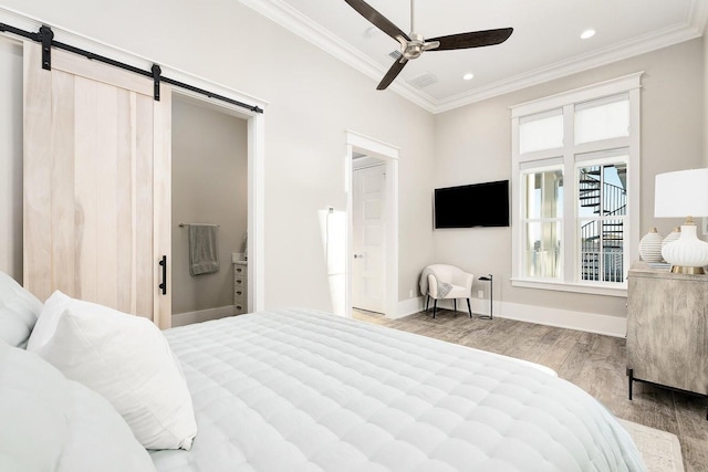 bedroom with ceiling fan, light hardwood / wood-style flooring, crown molding, and a barn door