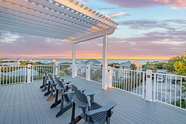 deck at dusk with a pergola and a water view