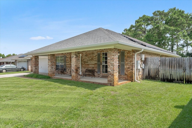 rear view of house featuring a garage and a yard