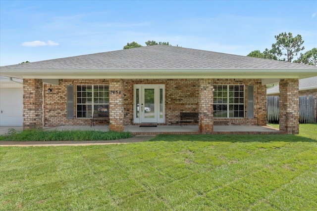 ranch-style home featuring french doors, a garage, and a front lawn