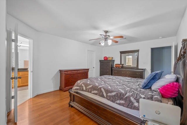 bedroom featuring light wood-type flooring, ceiling fan, and ensuite bath