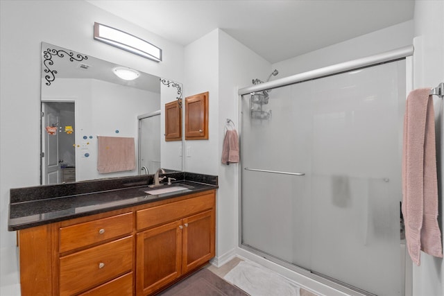 bathroom with tile patterned flooring, walk in shower, and vanity