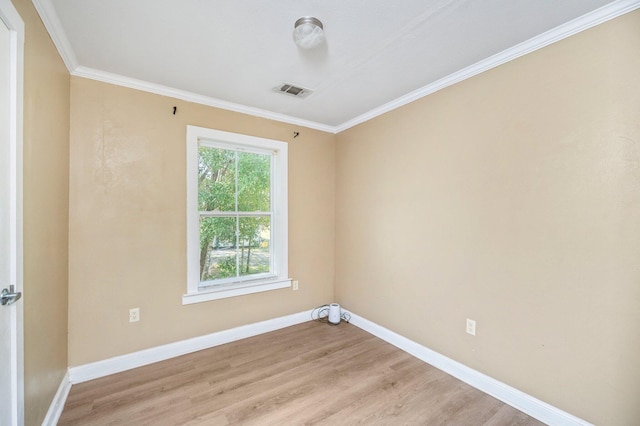 spare room featuring light wood-type flooring and ornamental molding