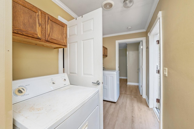 laundry room featuring light hardwood / wood-style flooring, ornamental molding, and cabinets