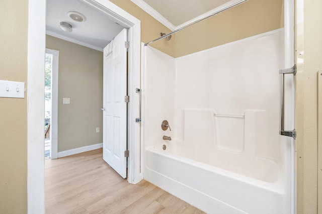 bathroom featuring hardwood / wood-style flooring, crown molding, and shower / bathing tub combination