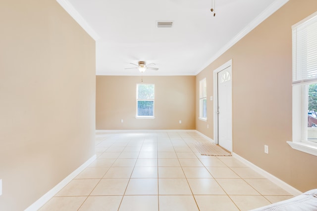 empty room with ceiling fan, light tile patterned floors, and ornamental molding