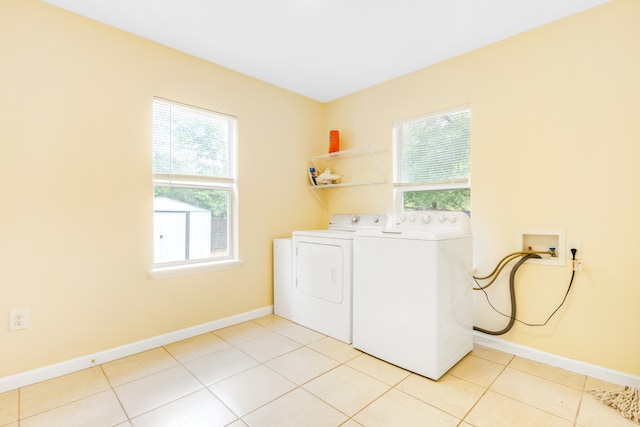 laundry room featuring a wealth of natural light, light tile patterned floors, and washer and clothes dryer