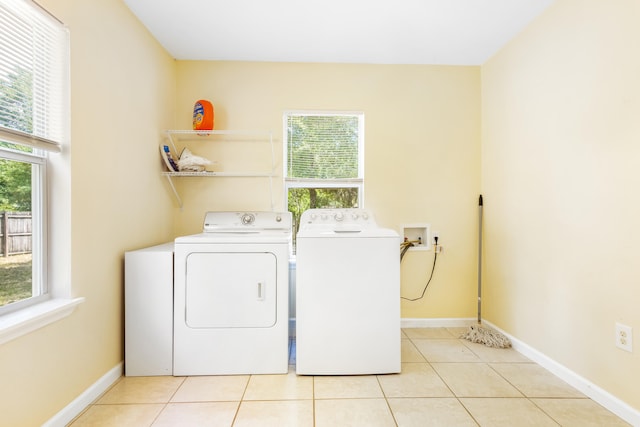 laundry area with separate washer and dryer and light tile patterned flooring