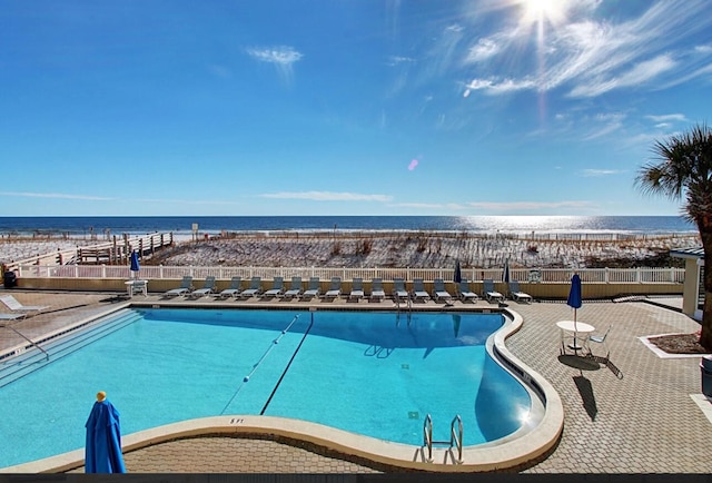 view of pool with a patio area and a water view