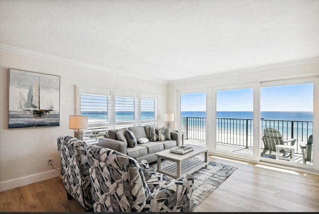 living room with crown molding, a water view, and hardwood / wood-style flooring