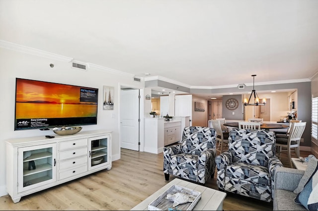 living room featuring light wood-type flooring, crown molding, and a chandelier