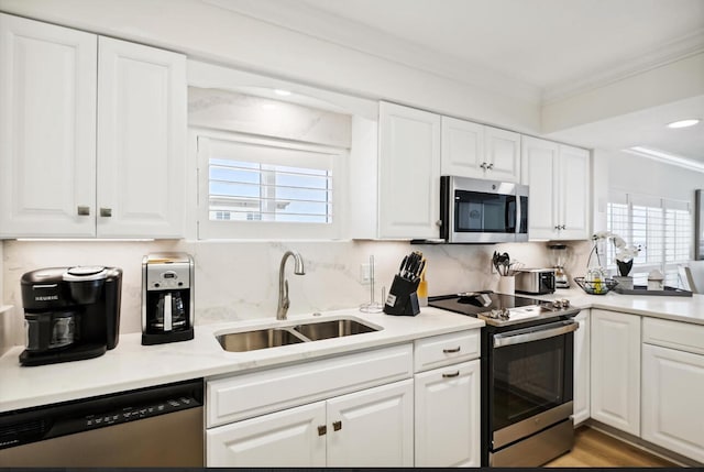 kitchen with a wealth of natural light, range, crown molding, and dishwashing machine