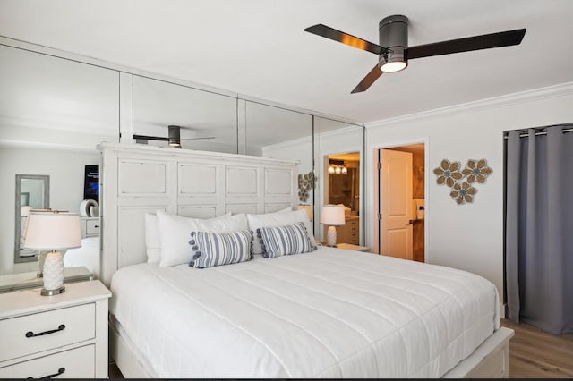 bedroom with hardwood / wood-style flooring, crown molding, and ceiling fan