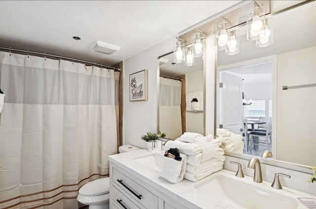 bathroom featuring toilet, a shower with shower curtain, an inviting chandelier, and vanity