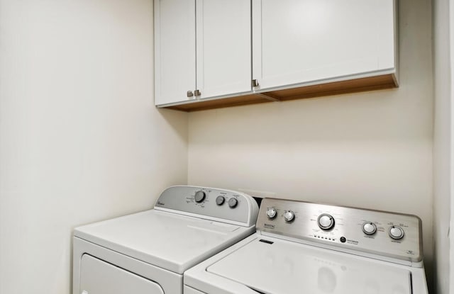 washroom featuring washer and clothes dryer and cabinets