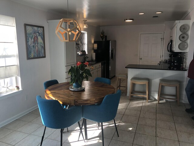 dining area featuring sink and light tile patterned flooring