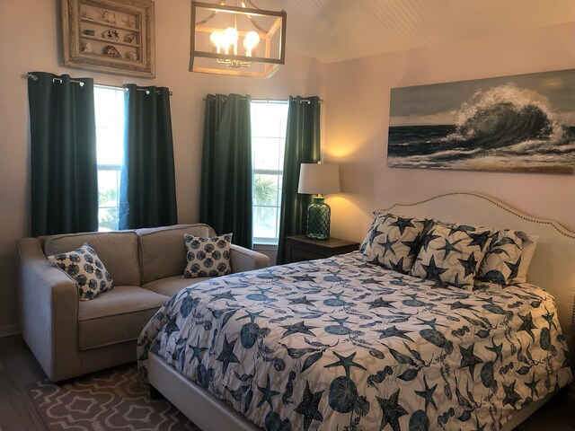 bedroom with hardwood / wood-style flooring and a notable chandelier