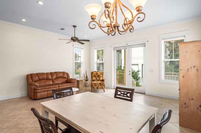 tiled dining area featuring plenty of natural light, ornamental molding, and ceiling fan with notable chandelier