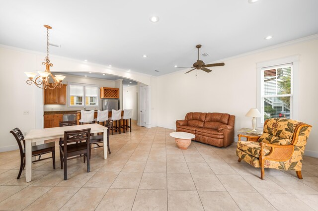 living room featuring ceiling fan with notable chandelier, ornamental molding, and a healthy amount of sunlight