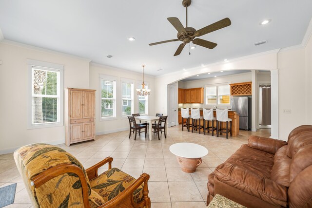 tiled living room featuring ornamental molding and ceiling fan with notable chandelier