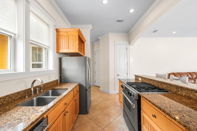 kitchen featuring light tile patterned floors, stainless steel appliances, ornamental molding, sink, and dark stone countertops