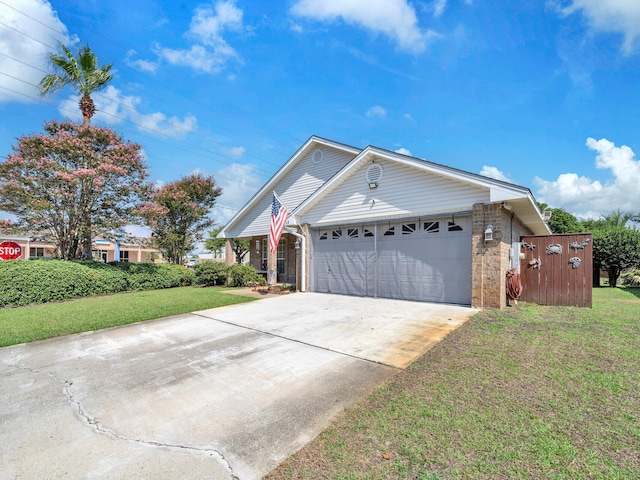 ranch-style home featuring a garage, concrete driveway, a front lawn, and brick siding