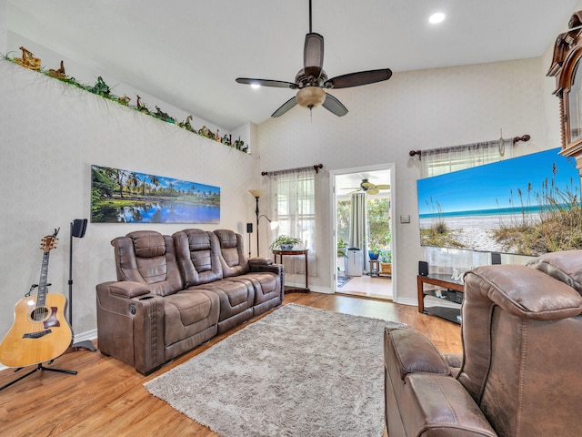 living room with light wood finished floors, a ceiling fan, and baseboards