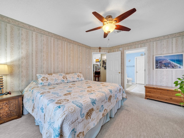 bedroom with ensuite bathroom, carpet floors, visible vents, and wallpapered walls