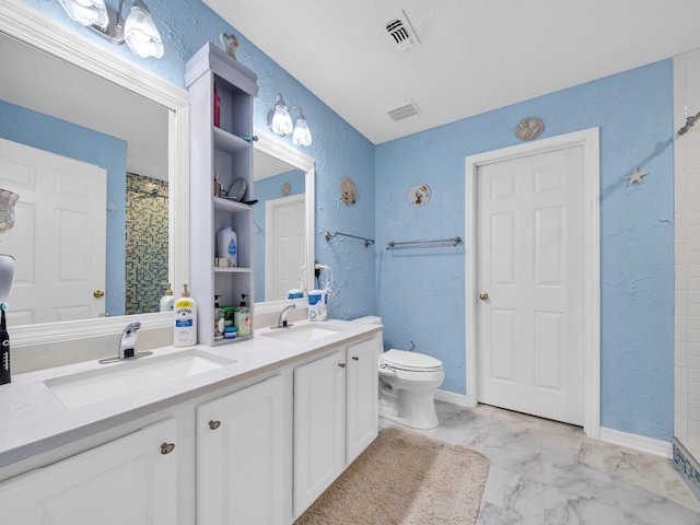 bathroom featuring vanity, toilet, and a textured ceiling