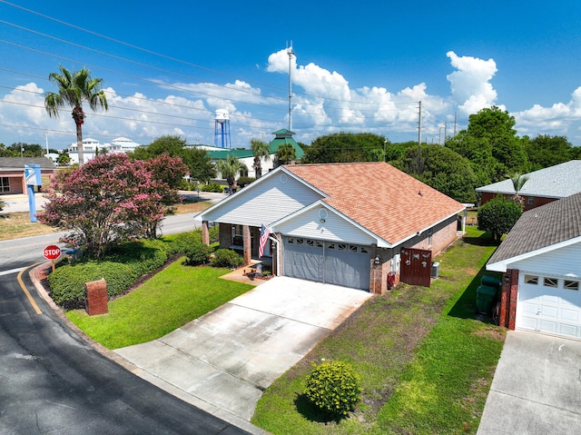 ranch-style home featuring an attached garage, brick siding, driveway, roof with shingles, and a front lawn