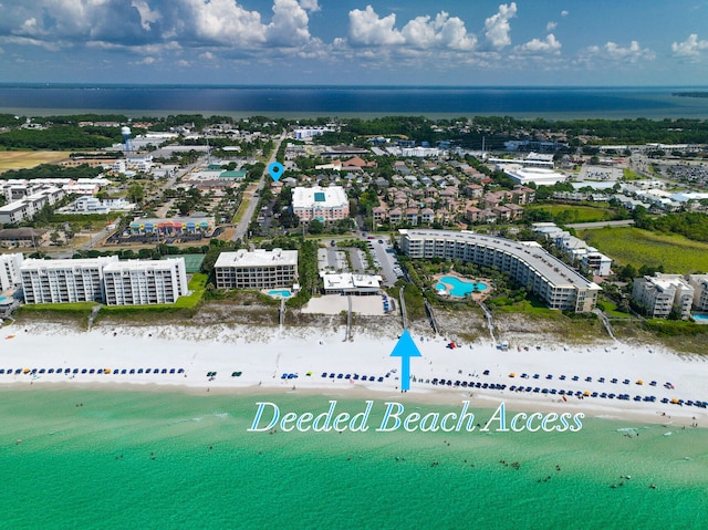 birds eye view of property featuring a water view and a beach view