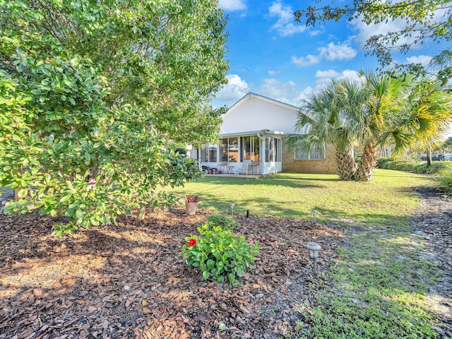 view of front of property with a sunroom and a front lawn