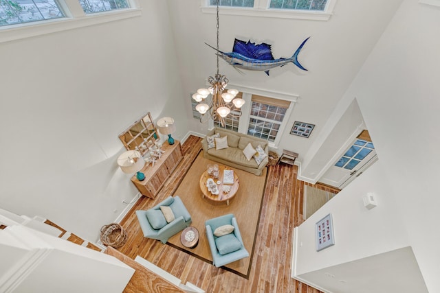 living room with a towering ceiling and hardwood / wood-style flooring