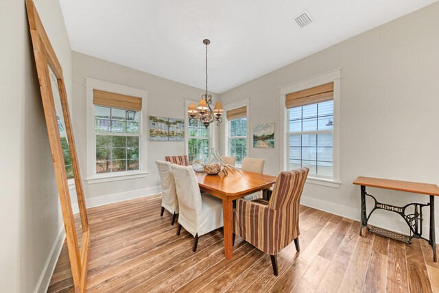 dining space featuring wood-type flooring and a chandelier