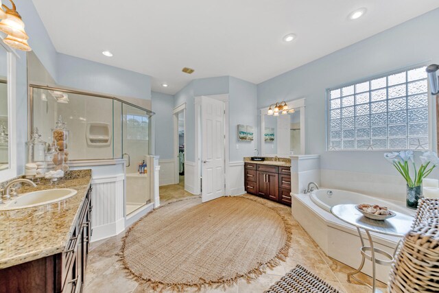 bathroom with tile patterned flooring, independent shower and bath, and vanity