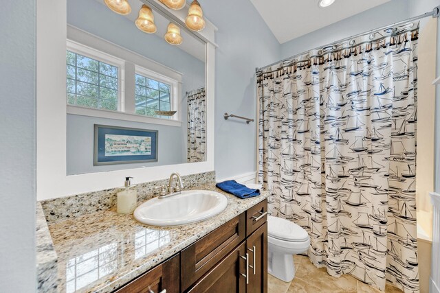 bathroom featuring tile patterned flooring, a shower with shower curtain, vanity, and toilet