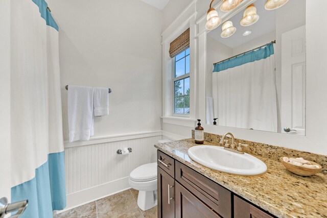 bathroom with tile patterned floors, vanity, walk in shower, and toilet