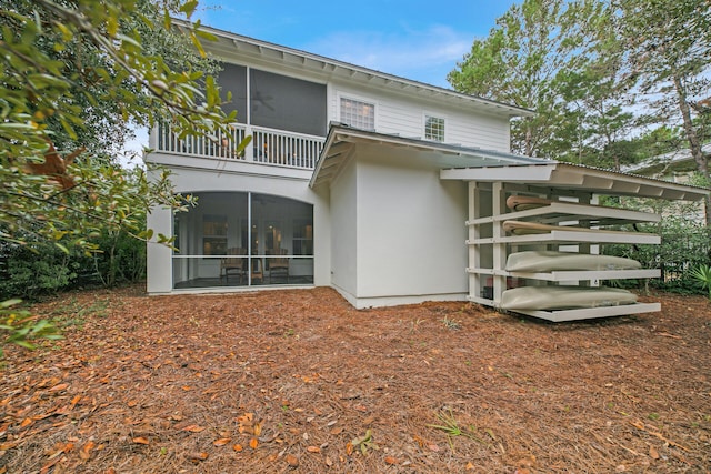 back of property with a sunroom and a balcony