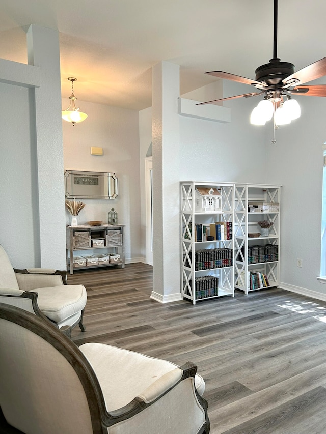 sitting room with ceiling fan and wood-type flooring