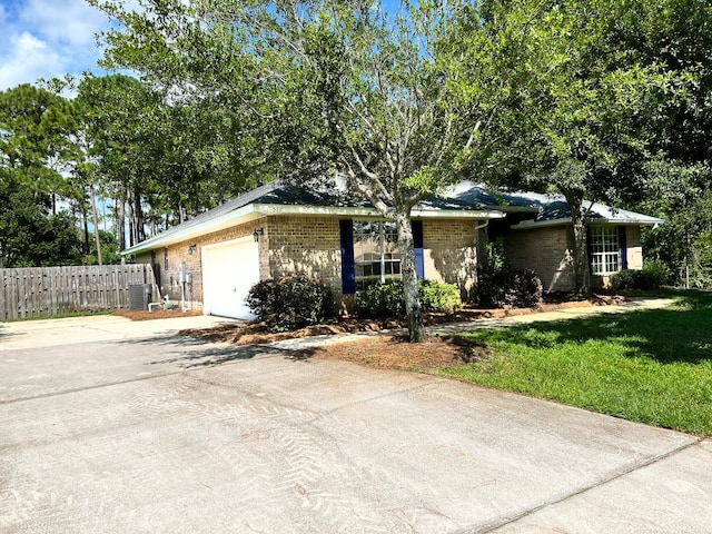 ranch-style home featuring central AC, a garage, and a front yard